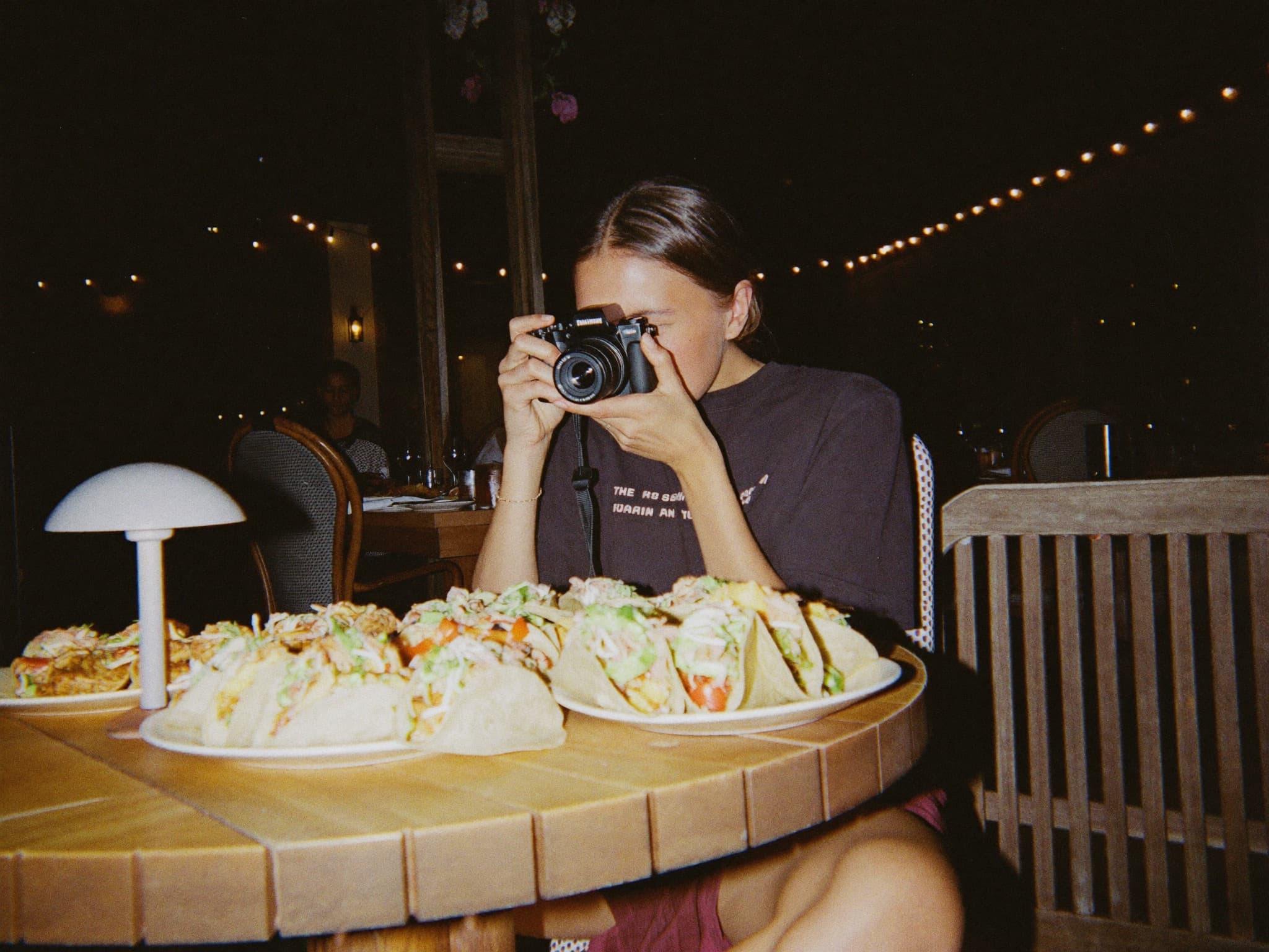 Creator at restaurant table shooting content — natural, not staged